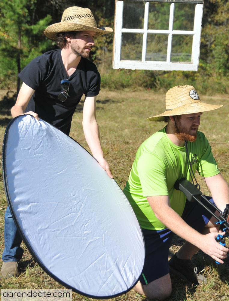 Director Aaron Pate and DP Jarod Phillips on set with disc reflector and camera