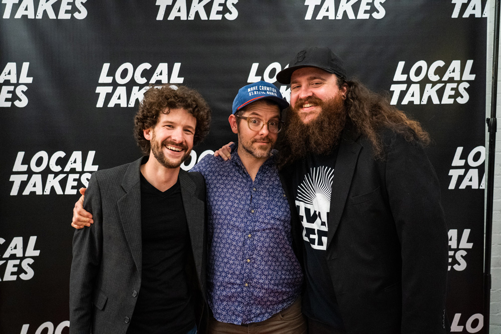 Artist Andrew Blanchard with Aaron Pate and Trey Morrow in front of Local Takes backdrop